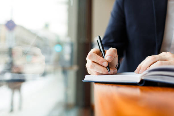 istock Businessman Writing in Planner at Cafe Window 685865726
