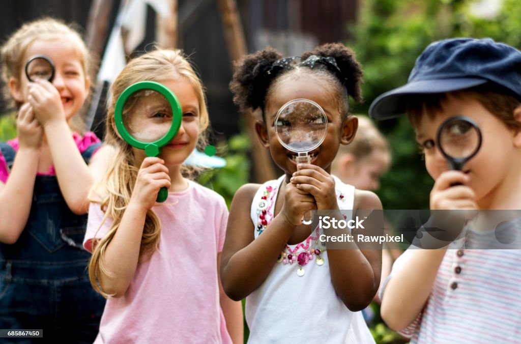Group of kindergarten kids friends holding magnifying glass for explore Child Stock Photo