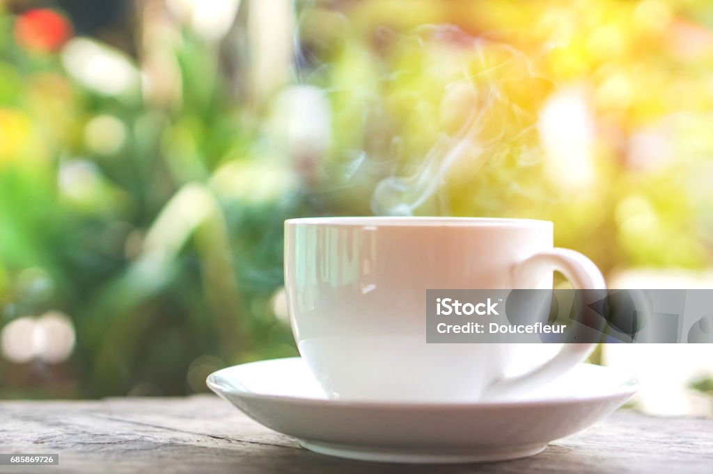 hot coffee cup on wooden table over green background hot coffee cup on wooden table over nature green morning background Coffee Cup Stock Photo