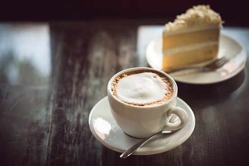 cup of coffee and cake on wooden table