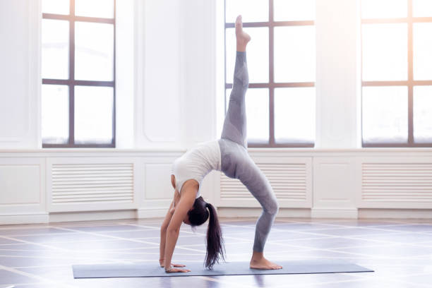 istock Young woman in white doing yoga pose 685870644