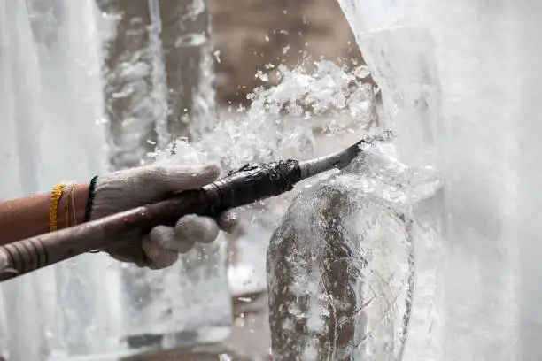 Photo of man is carving the ice sculpture for wedding