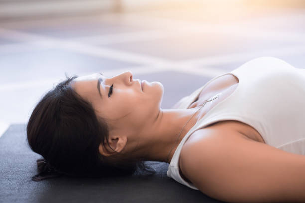 Young woman meditating on a wooden floor stock photo