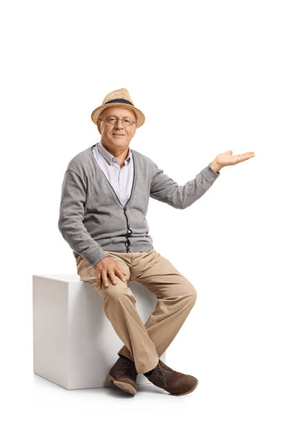 istock Senior sitting on a cube and gesturing with his hand 685873600