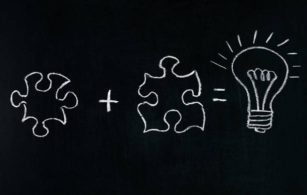 istock Businessmans Hand drawing puzzle on blackboard to explain business concept. Solving puzzle together. Drawing light bulb on blackboard. Combining the wisdom for developing new idea. 685875266