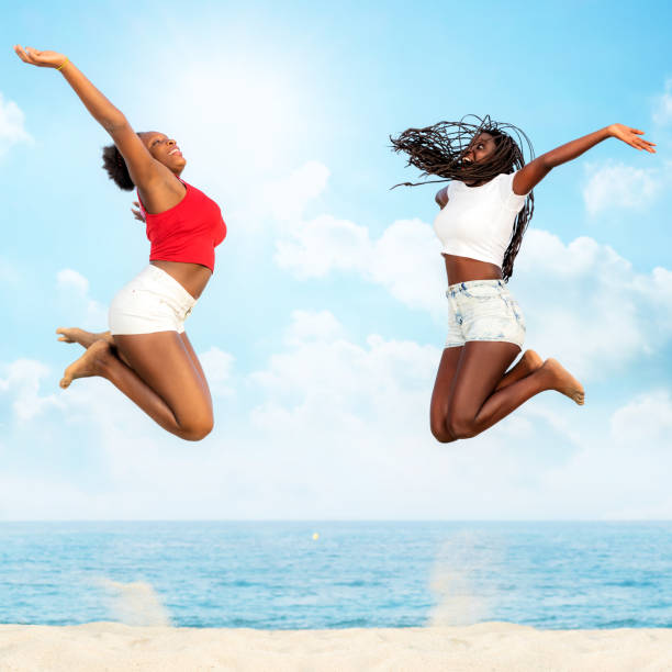 istock Two african friends jumping together on beach. 685878088