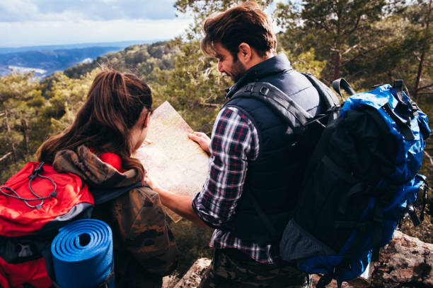 istock Couple on a hiking adventure looking at map for directions 685879384