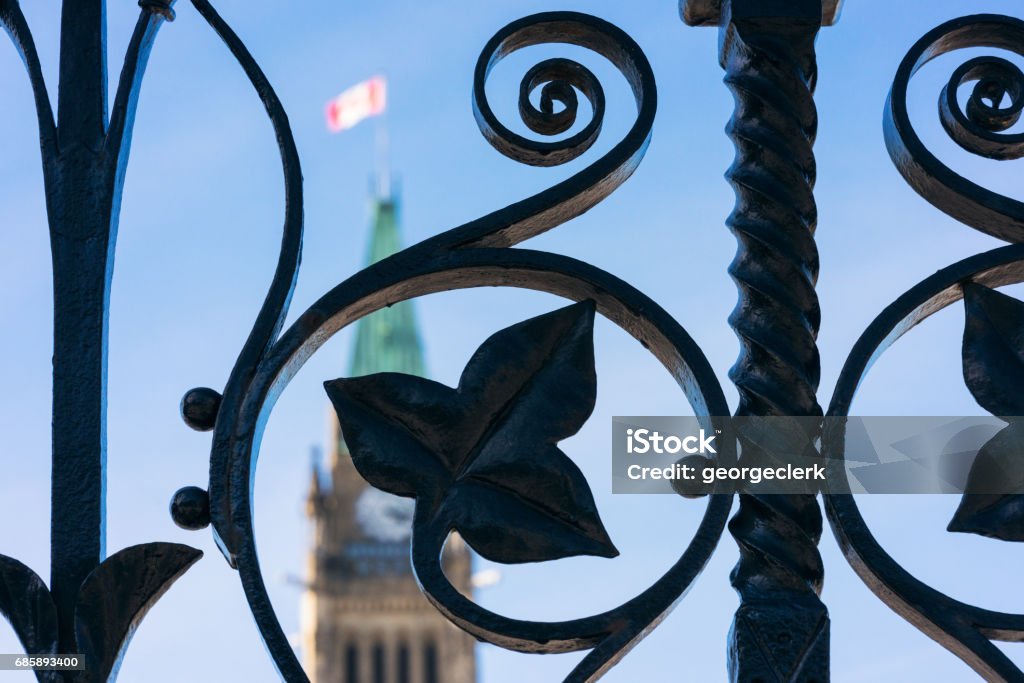 Intricate railings in front of the Canadian Parliament Building A close-up of wrought iron railings, with the Canadian Parliament's tower defocused in the background. Parliament Building Stock Photo