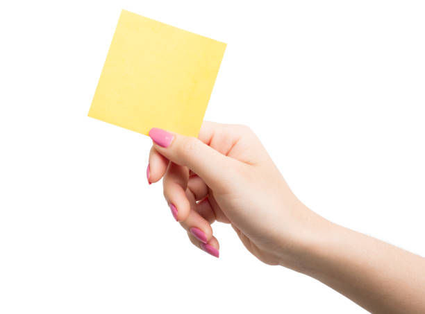 mano donna che tiene in bianco carta da nota gialla - sticky memories yellow white foto e immagini stock
