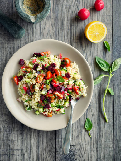 Home made healthy brown rice salad.tossing cooked brown rice with basil,cucumber and olive oil,service with beetroot salsa