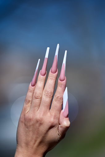 unrecognizable fashion model hand with long artificial nails, glamour manicure.photo taken outdoors.