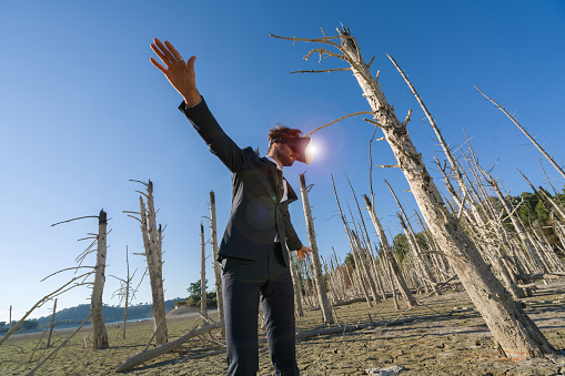 Image of a businessman with vr headset on the arid area.