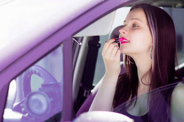 istock female driver takes lipstick 685924140