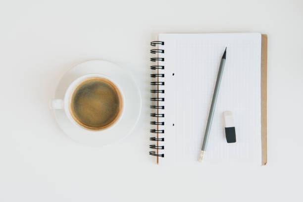 istock Top view of notebook with pencil and rubber and cup of coffee on table top 685928056