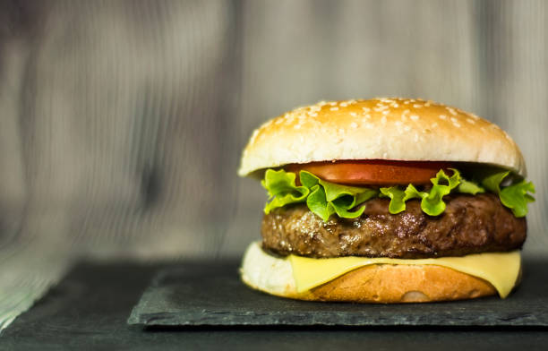 istock Delicious hamburger with cheese, lettuce and tomato on a stone 685945804