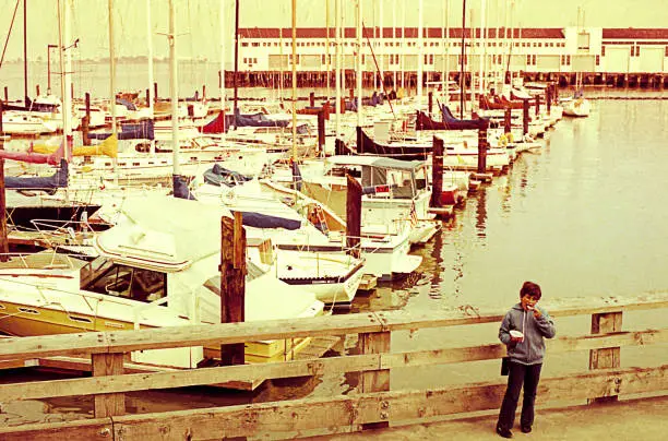 Vintage photo of a boy in the pier at San Francisco during a tirp in the eighties.