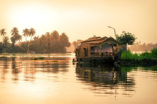 Una casa flotante bien decorada estacionada a los lados del canal de aguas atrás en Alleppey en Kerala photo