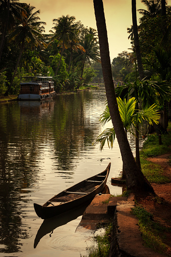 Una canoa estacionado en los lados del canal de drenaje en una tarde nublada parcial en Alleppey en Kerala photo
