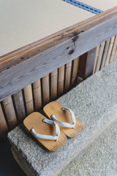Geta or traditional Japanese footwear, a kind of flip-flops or sandal with an elevated wooden base held onto the foot with a fabric thong strap Geta or traditional Japanese footwear, a kind of flip-flops or sandal with an elevated wooden base held onto the foot with a fabric thong strap geta sandal photos stock pictures, royalty-free photos & images