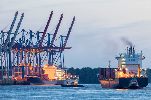 Cargo Terminal, Large Container Ship Assisted By Tugboats in Hamburg Harbor, Germany
