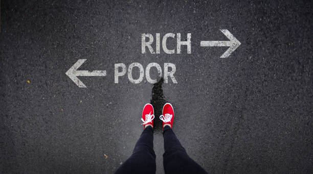 istock Red shoes standing next to rich and poor written in paint 686051150