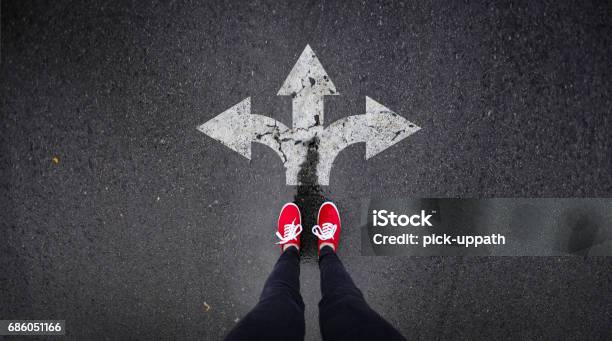 Red Shoes Standing Next To Arrows Painted In Road Stock Photo - Download Image Now - Expertise, Mistake, Arrow Symbol