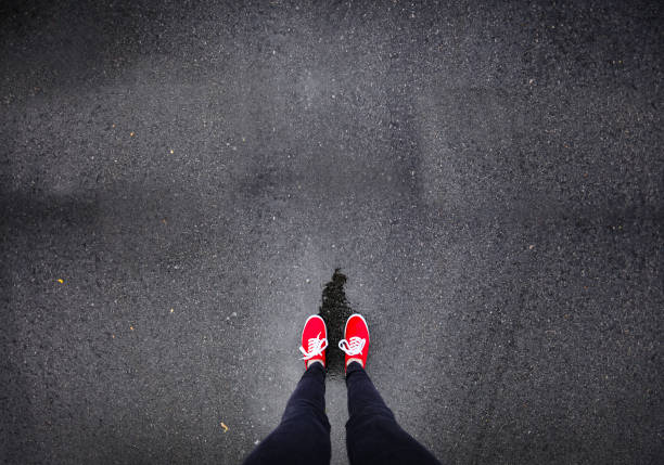 istock Red shoes walking in rain 686051192