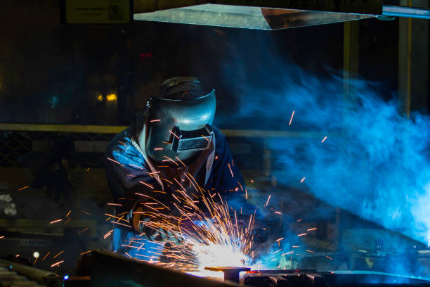 istock Worker with protective mask welding automotive part in factory 686062764