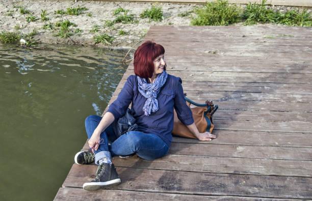 istock A woman sitting on a wooden pontoon 686062920