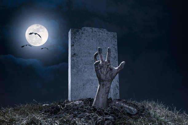 Zombie Hand Halloween Graveyard Night Monster Scary A zombie hand bursting through the grave in a graveyard on Halloween night under a full moon with vampire bats. zombie stock pictures, royalty-free photos & images