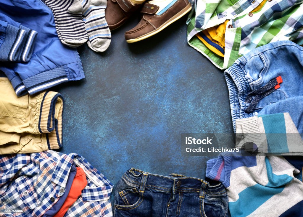 Fashion background with set of baby clothes Fashion background with set of baby clothes on a dark blue slate,stone or concrete backdrop.Top view with copy space. Child Stock Photo