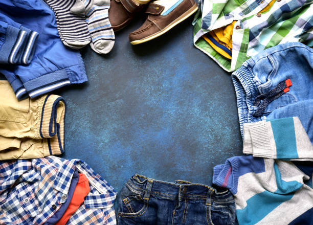 Fashion background with set of baby clothes Fashion background with set of baby clothes on a dark blue slate,stone or concrete backdrop.Top view with copy space. corduroy jacket stock pictures, royalty-free photos & images