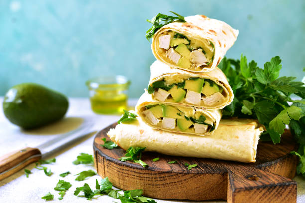 istock Chicken avocado burritos on a wooden cutting board o 686070970