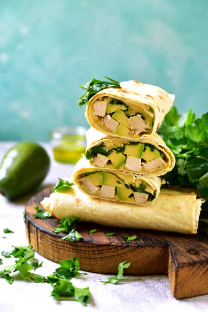 istock Chicken avocado burritos on a wooden cutting board o 686070974