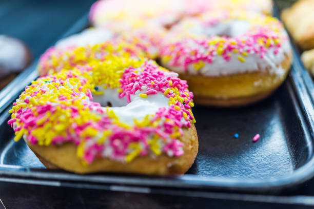 istock Vanilla white iced donuts with pink and yellow sprinkles 686074986