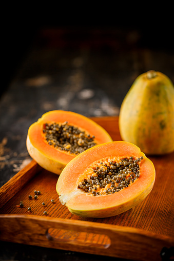 A closeup of a papaya cut in half isolated on a white background