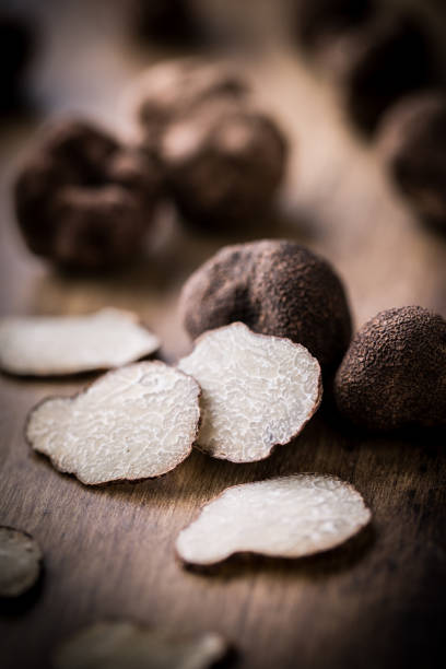 черные трюфели и ломтики на черном - truffle стоковые фото и изображения