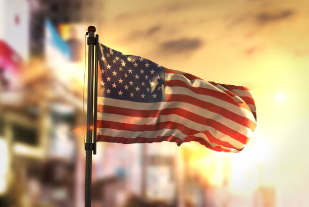 istock American Flag Against City Blurred Background At Sunrise Backlight 686124158