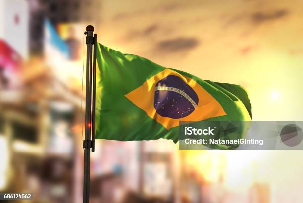 Brazil Flag Against City Blurred Background At Sunrise Backlight Stock Photo - Download Image Now