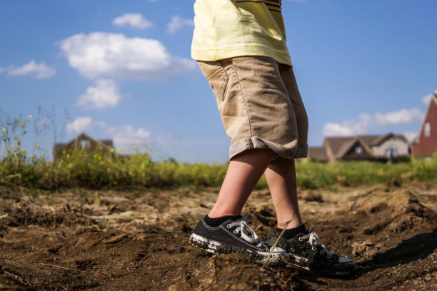 istock Boy Walking In Mud Wearing Black and White Sneakers 686126832