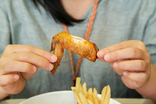 girl eating fried chicken wing