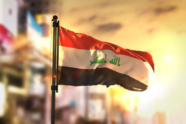 Iraq Flag Against City Blurred Background At Sunrise Backlight Iraq Flag Against City Blurred Background At Sunrise Backlight iraqi flag stock pictures, royalty-free photos & images