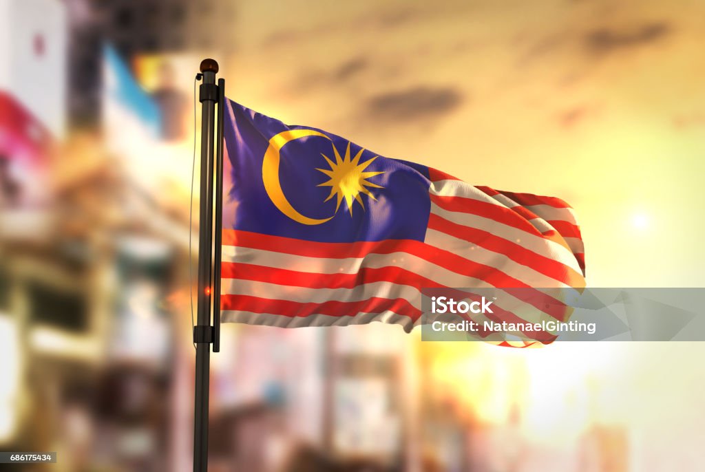 Malaysia Flag Against City Blurred Background At Sunrise Backlight Malaysian Flag Stock Photo