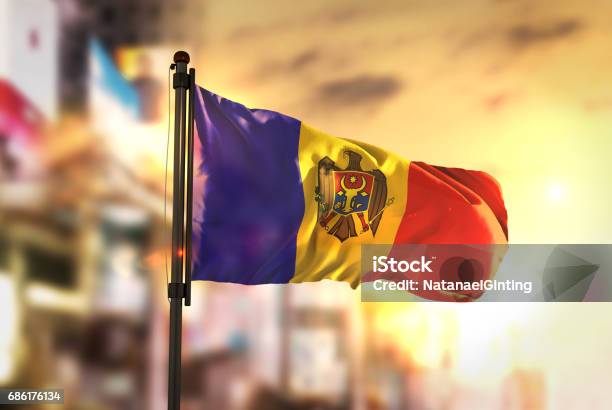 Moldova Flag Against City Blurred Background At Sunrise Backlight Stock Photo - Download Image Now