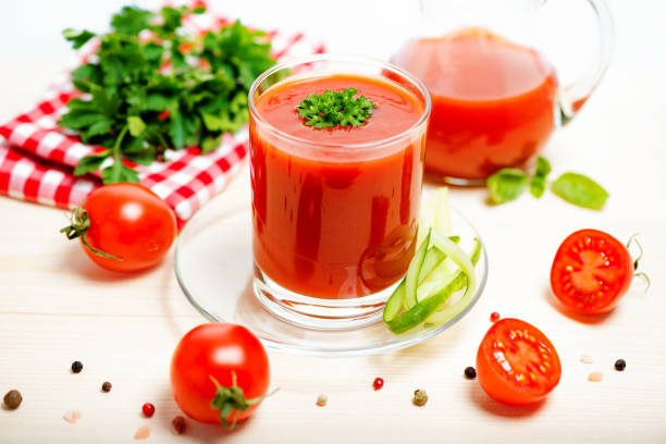 istock tomato juice in glass, jug with greenery, basil, cutted tomato fruit and dry pepper on light wooden background, concept vegetarian food, close up 686178710