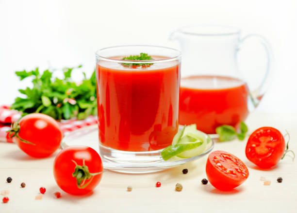 istock tomato juice in glass, jug with greenery, basil, cutted tomato fruit and dry pepper on light table, concept vegetarian food, close up 686178714