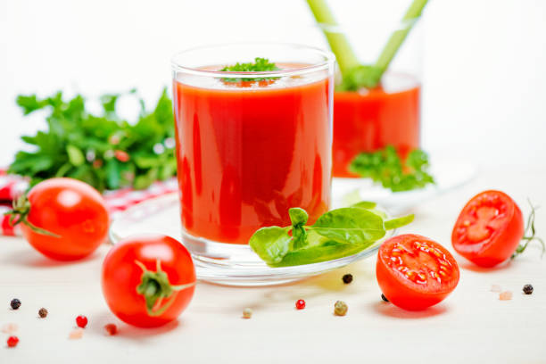 tomato juice in glasses with greenery, basil, cutted tomato fruit and napkin on light wooden background, concept vegetarian food, close up - basil tomato soup food and drink imagens e fotografias de stock