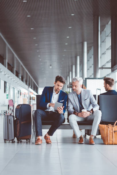 istock Two businessman using digital tablet at airport lounge 686181610