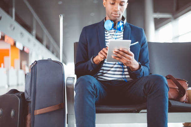 istock Young man using digital tablet at airport lounge 686181710