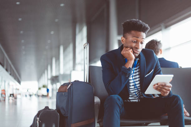 istock Young man at airport waiting lounge using digital tablet 686182042